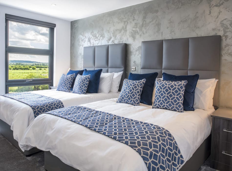 Two beds in room with view out of window