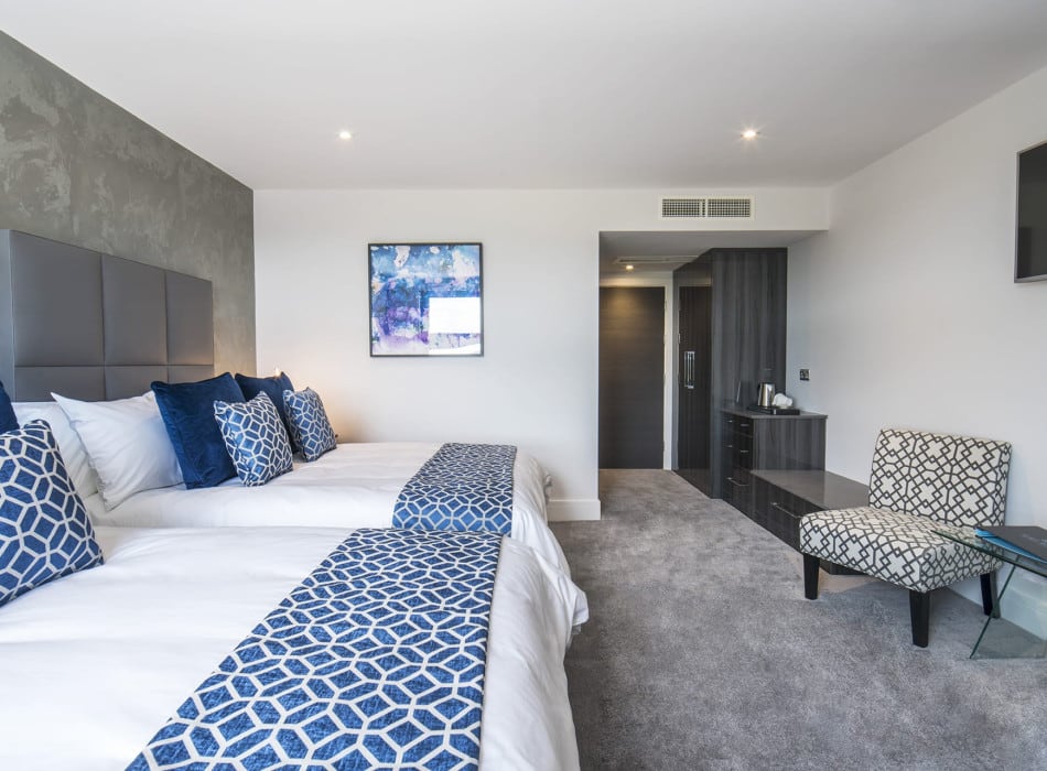 Two beds, with desk and chairs in room