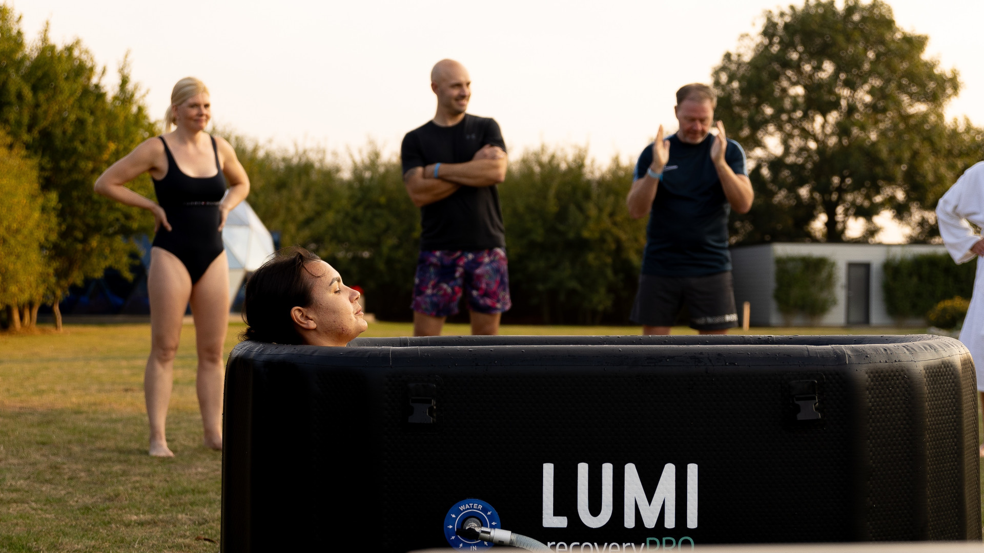 Group cold‑water therapy session at Glass House Wellness Retreat using LUMI recovery tubs outdoors.