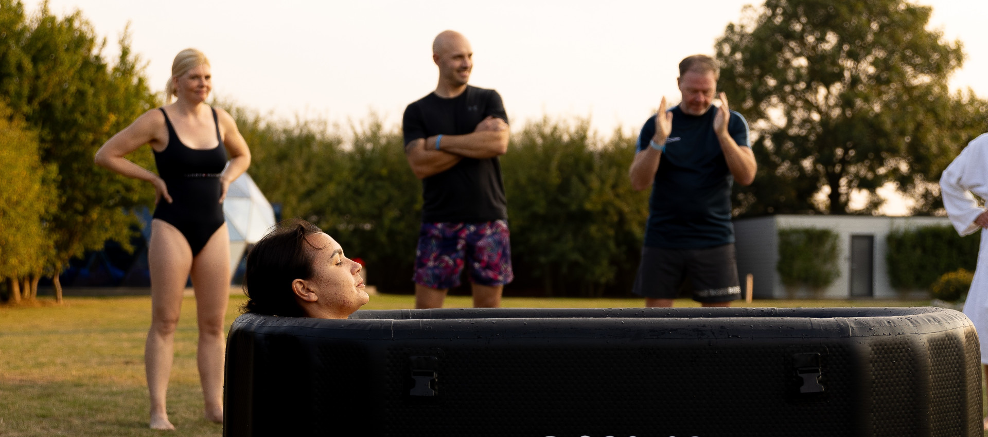 Group cold‑water therapy session at Glass House Wellness Retreat using LUMI recovery tubs outdoors.