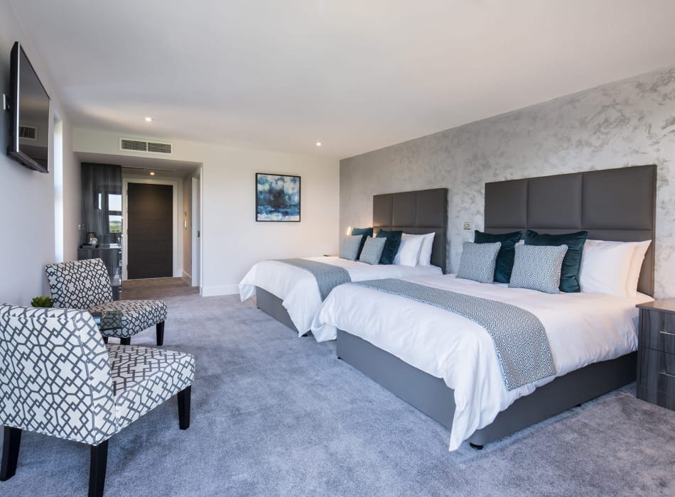 Two beds and chairs in room