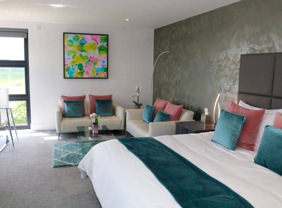 Bed and sofas in room with view from window