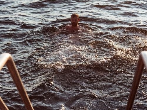 man swimming in cold water